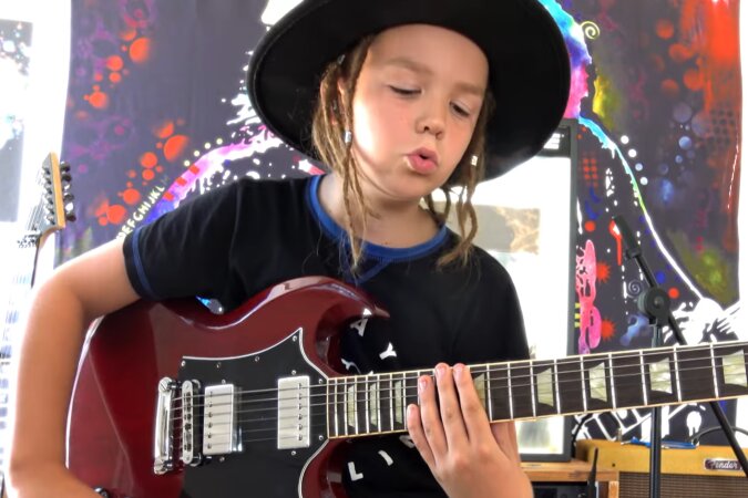 Junges Talent: Ein neunjähriger Junge spielt Gitarre wie der Frontmann von AC/DC