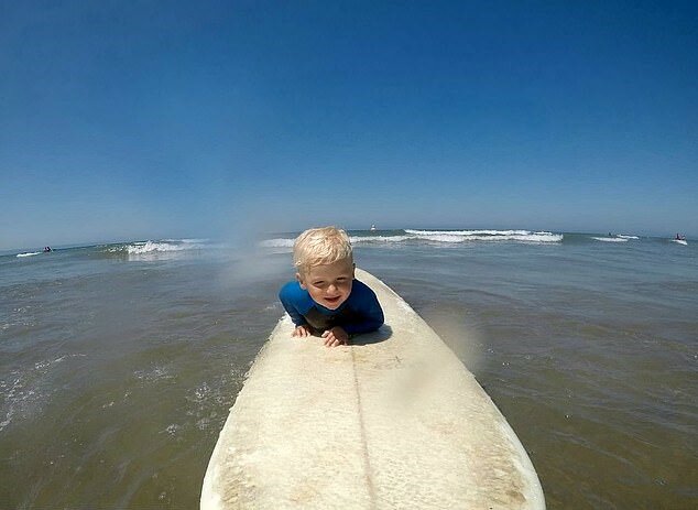 4 Jahre alter Junge reitet die Wellen wie ein Erwachsener
