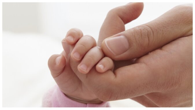 Eine Mutter hält die Hand ihrer kleinen Tochter. Quelle: Getty Images